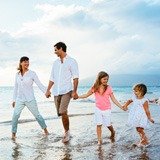 Familia de 4 personas caminando por la playa